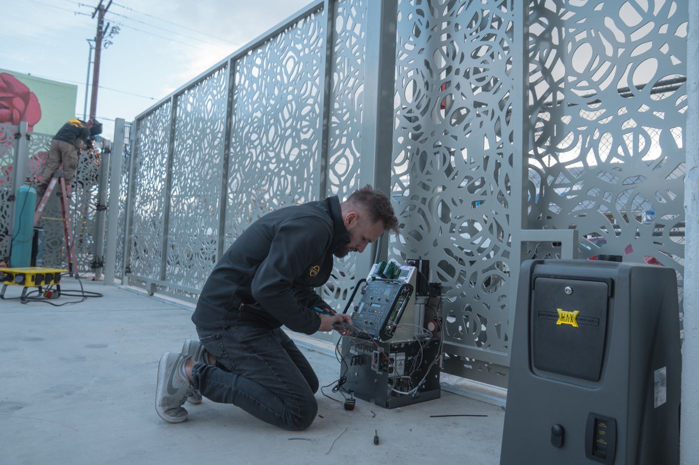Technician installing an automatic gate operator